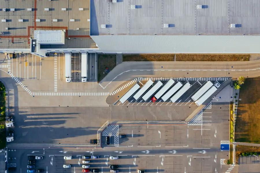 Aerial view of a logistics facility with trucks at the loading docks