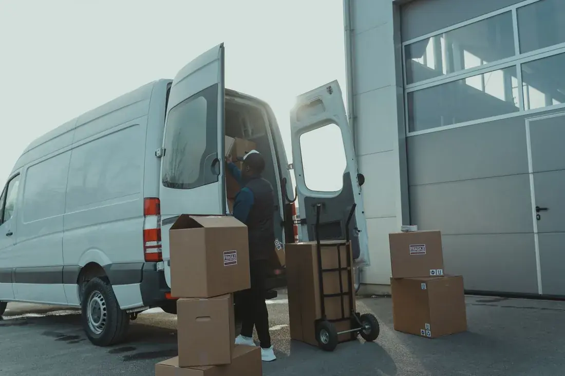 Parcels being unloaded from a delivery van at a warehouse